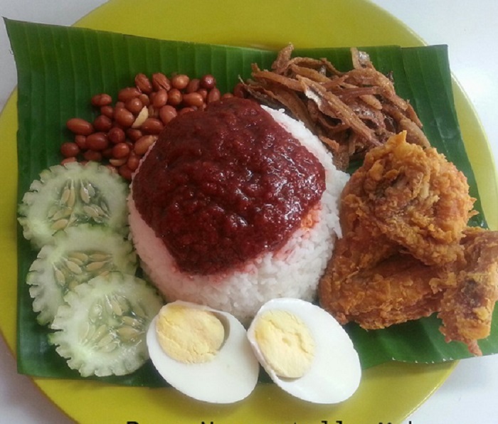 Sebungkus nasi lemak kukus dengan sambal, telur rebus dan timun.