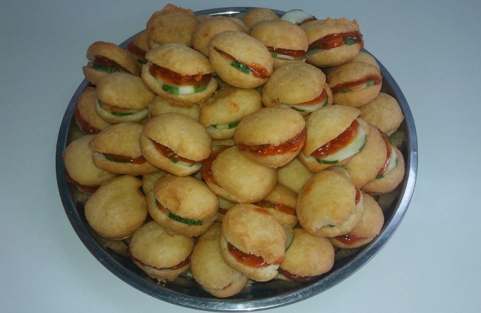 Gambar burger Malaysia mini yang gebu dengan inti sambal sardin dan hirisan timun.