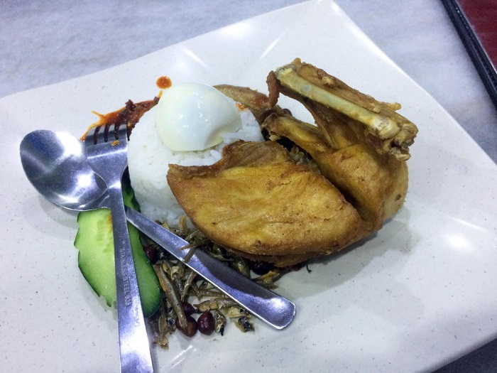 Hidangan nasi lemak dengan ayam kampung goreng, telur rebus, kacang dan ikan bilis.