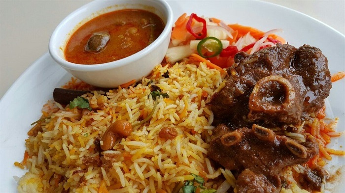 Pinggan nasi briyani berempah dengan lauk dan kuah.