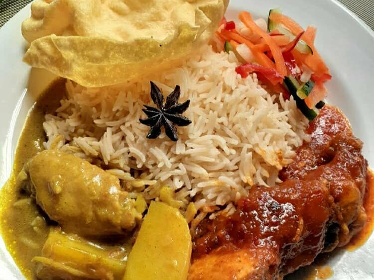 Nasi minyak kuning yang wangi dihidang bersama ayam masak merah dan acar timun