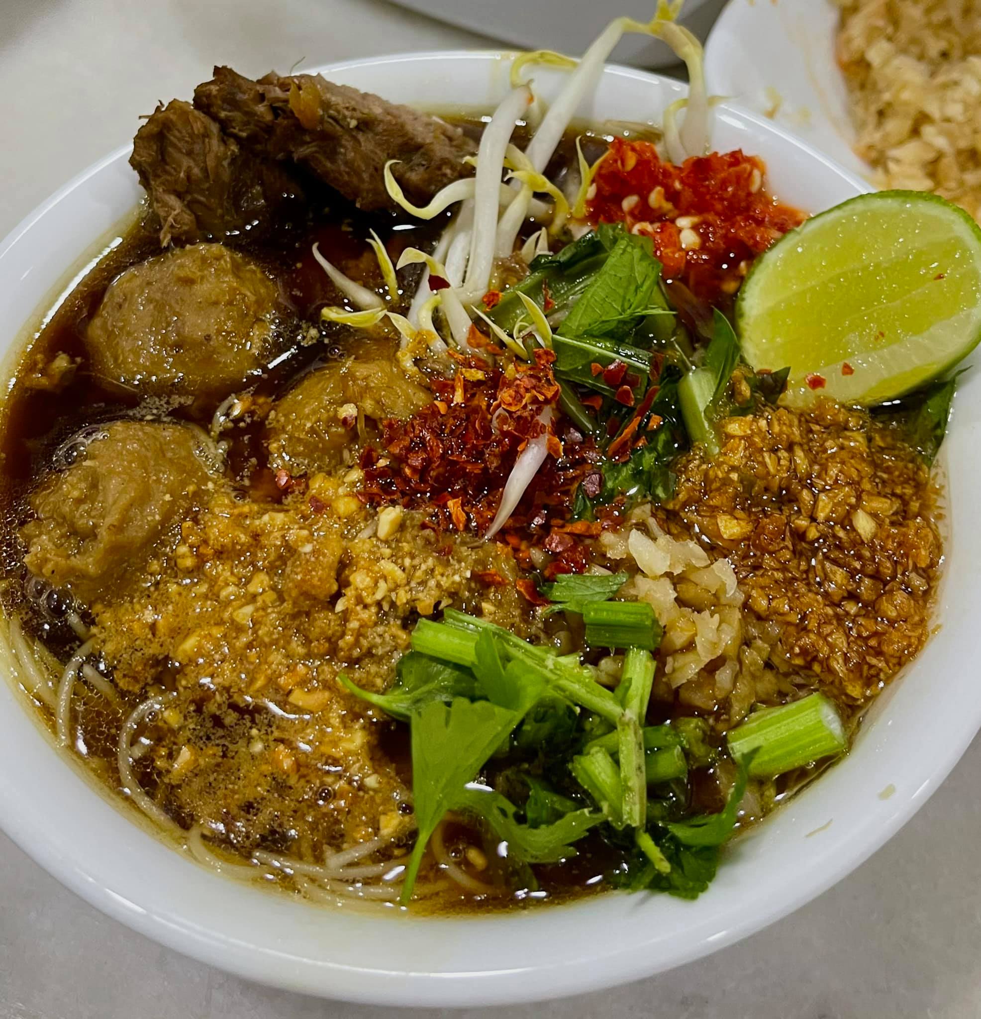 Mee celup Thailand dengan kuah, mi, sayuran dan cili jeruk.