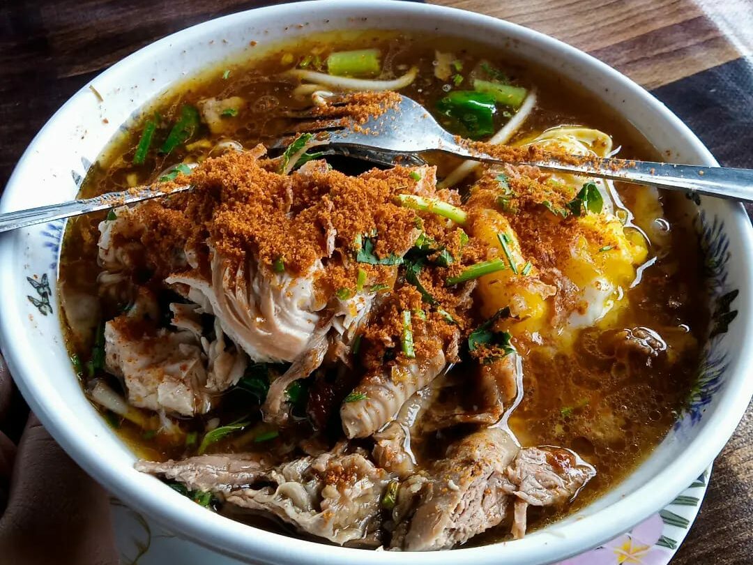 Mangkuk mee celup Kelantan dengan telur dan sup pekat yang sedap.