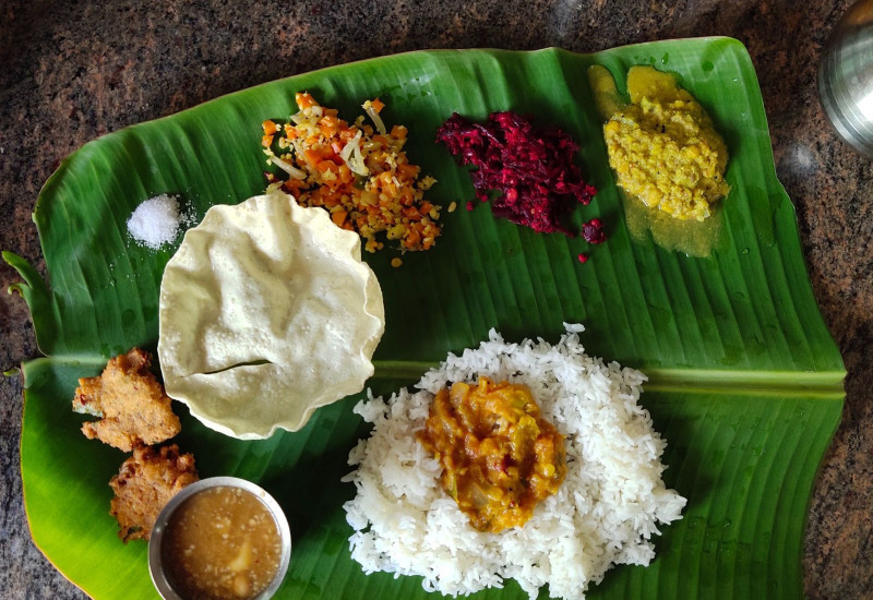 Hidangan nasi daun pisang dengan pelbagai lauk dan kari pekat
