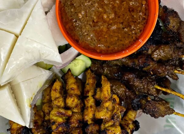 Sate dicucuk lidi disajikan bersama kuah kacang.